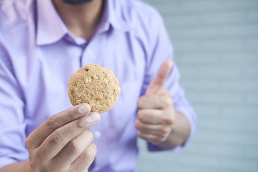 young man eating whole meal cookies .