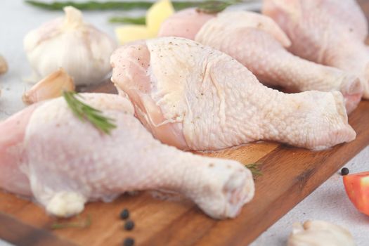 raw chicken drumstick on a chopping board .