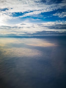 Aerial view from plane to morning sunrise over clouds 