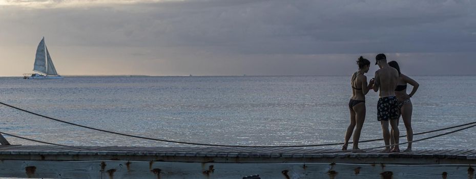 Friends on sunset pier vacation, banner image with copy space