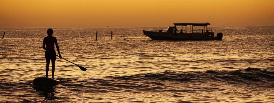 Surfer at sunset, banner image with copy space