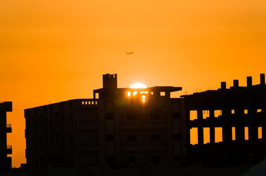 Plane take off at sunset over city ruins