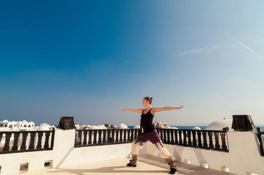 Attractive redhair woman practicing Vinyasa yoga outdoors