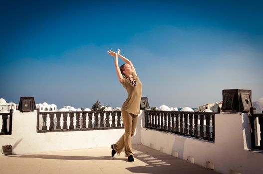 Attractive redhair woman practicing Vinyasa yoga outdoors