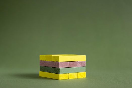 Jenga wood colourful green and yellow on green background copy space, platform for product copy space