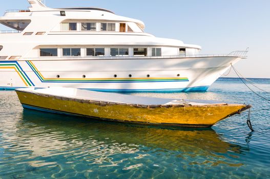 Old boat and modern yacht together in harbour