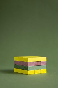 Jenga wood colourful green and yellow on green background copy space, platform for product copy space 