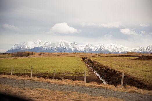 Iceland terrain with green and orange colors with waterway creating lines