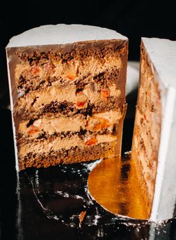 Amazing Cakes. Sliced chocolate wedding cake cake with amazing filling on a black background.Large cake in white chocolate.