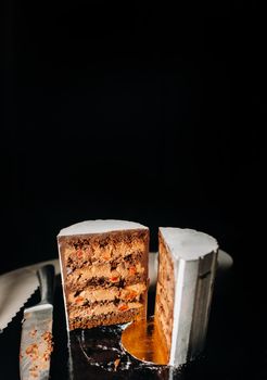 Amazing Cakes. Sliced chocolate wedding cake cake with amazing filling on a black background.Large cake in white chocolate.