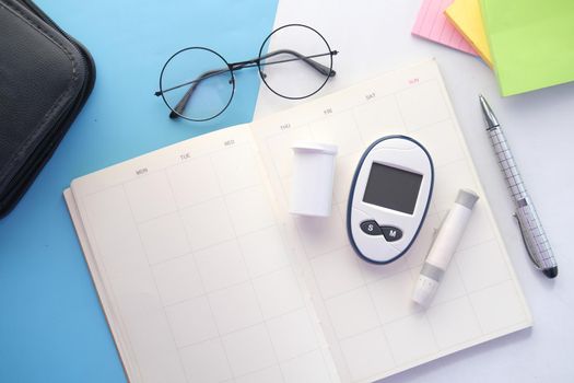 diabetic measurement tools on a planner on table .
