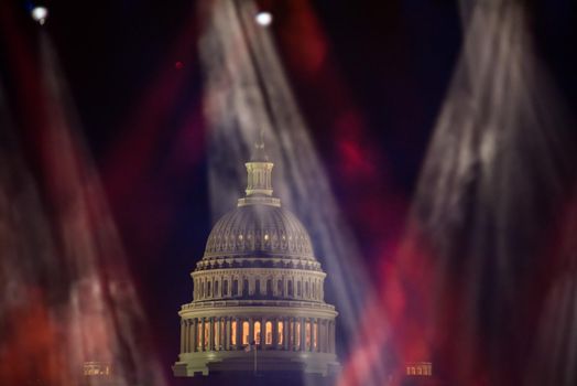 Washington, DC Spotlights over the Washington DC skyline with the Capitol Building at night.