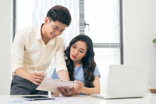 Business people working with computer and doing some paperwork while sitting at desk 