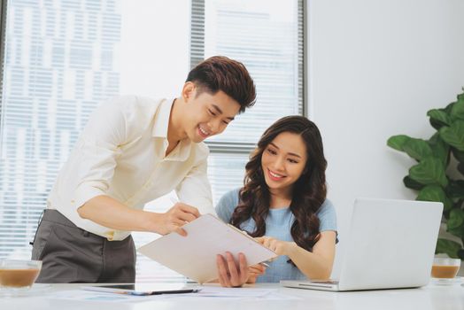 Business people working with computer and doing some paperwork while sitting at desk 