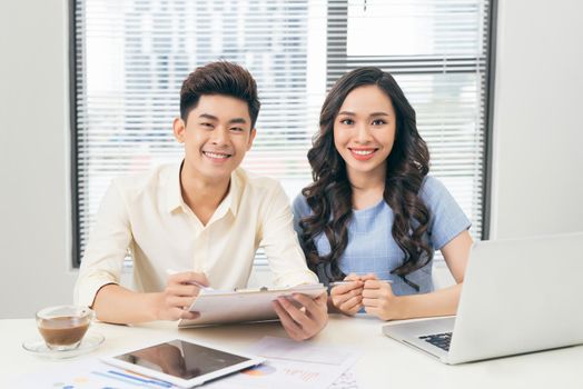 Business people working with computer and doing some paperwork while sitting at desk 