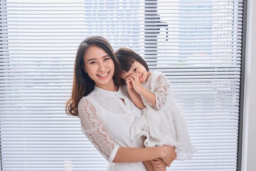 Mother and baby girl making fun in living room.Laughing.Mother holding her daughter.