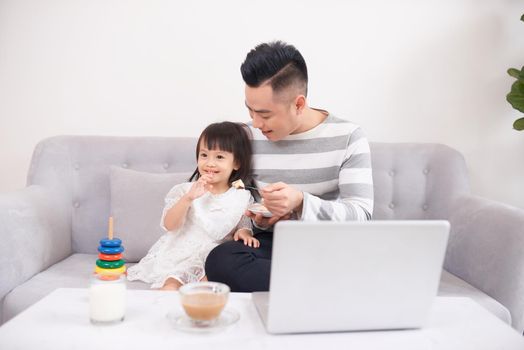 Father and his teenage daughter playing on a portable computer at home.