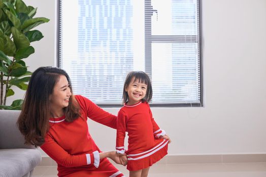 Happy young mother laughing with her little daughter in the morning. Having fun together. Joyful family time at home. 