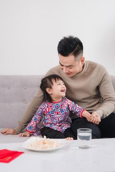 Vietnamese Father and Daughter celebrate new year at home. Tet Holiday.