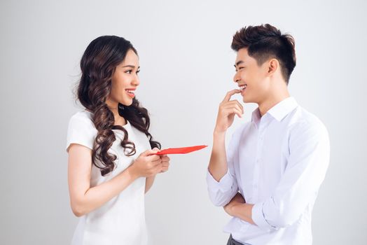 Vietnamese couple exchanging red lucky money envelopes. Tet holiday.