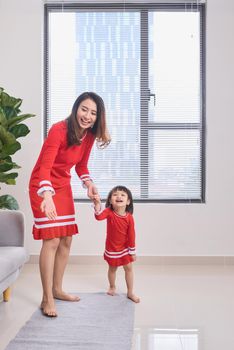 Happy young mother laughing with her little daughter in the morning. Having fun together. Joyful family time at home. 