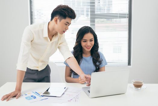 Business people working with computer and doing some paperwork while sitting at desk 