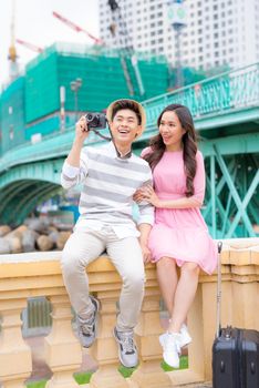 Young man and pretty girl are having fun in the city at evening.