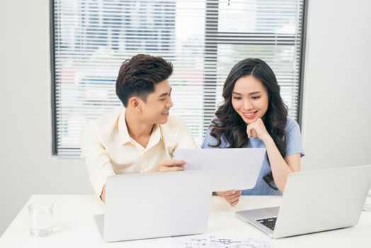 Young business team working together at a laptop, man and woman