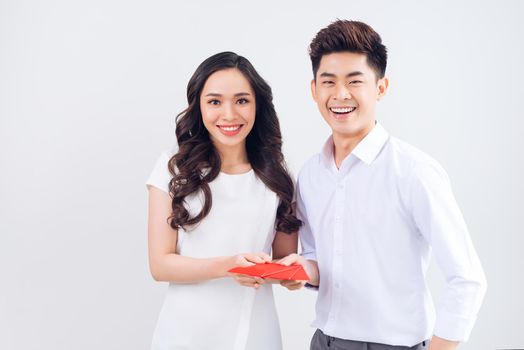 Vietnamese couple exchanging red lucky money envelopes. Tet holiday.