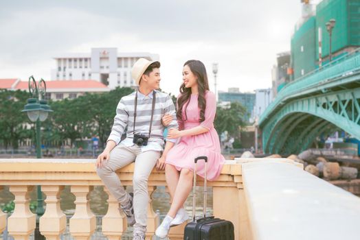 Couple of happy tourists sitting together in the city center