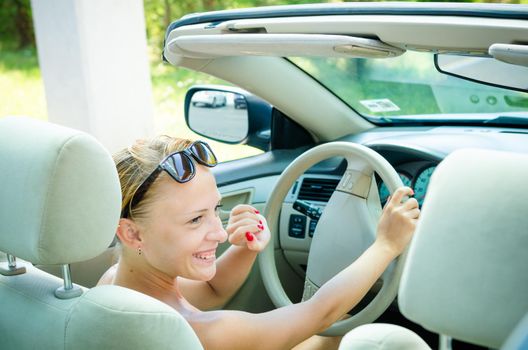 Beautiful blond woman driving her convertible car