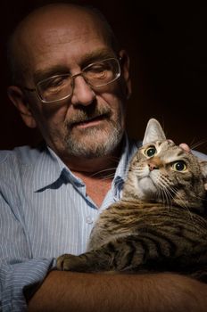 Low key shot of mature man with his cat