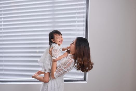 Mother and baby girl making fun in living room.Laughing.Mother holding her daughter.