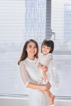 Mother and baby girl making fun in living room.Laughing.Mother holding her daughter.