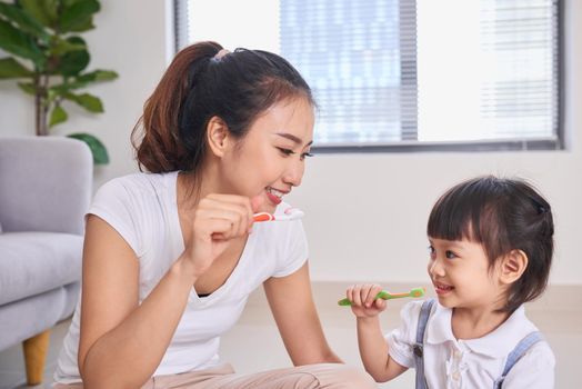 Mother and daughter brushing their teeth