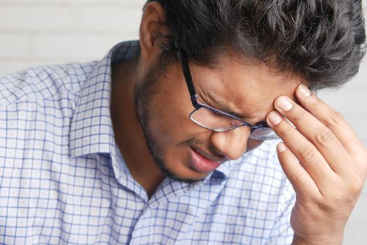 Depressed man feeling sick and worried about financial problem.