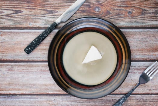 fresh cheese on a plate of on wooden background.,