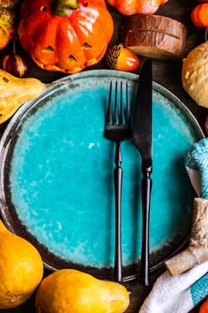 Autumnal table setting with leaves and  pumpkin on wooden table