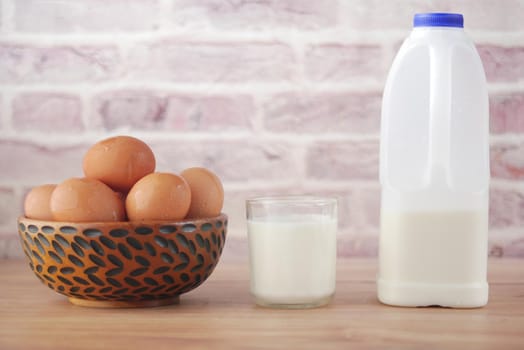 eggs in a bow and a glass of milk on table ,