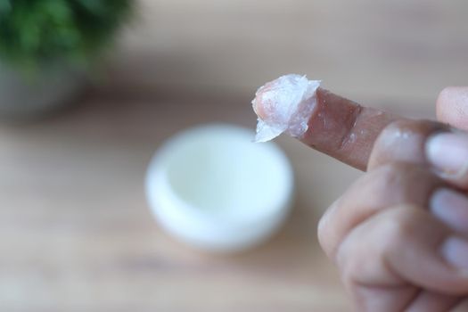Close up of man hand using petroleum jelly .