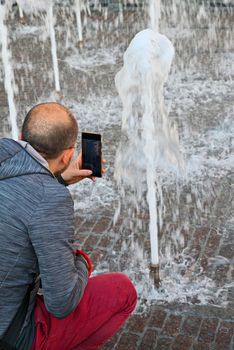 terni,italy september 18 2021:tourist photographs the jets of water of a fountain