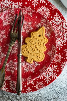 Festive table setting decorated with gingerbread cookie for Christmas dinner