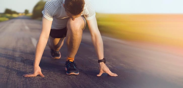 A young man trains and runs early in the morning, the athlete prepares for the race at the start.