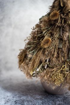 Christmas interior decoration with xmas tree made with dry grass, branches and leaves