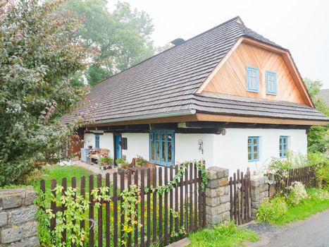 Lichnice village, Czechia. 26th of August 2021. Restored historic timbered cottage with a layer of clay on the peripheral wall, the so-called fur coat. Classic shingle roof.