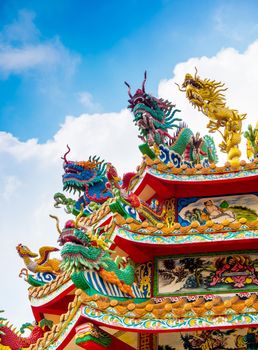 Colorful chinese dragon and swan statues adorned the rooftops of pavilions in Chinese religious venues