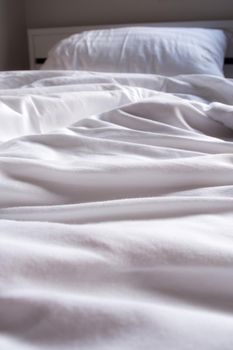 White blanket crumpled on the bed