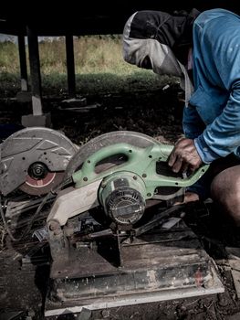 Male worker cutting steel with a cutting machine