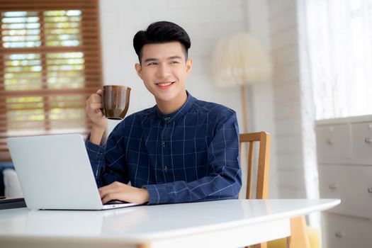 Young business man working from home with laptop computer on desk, freelance male sitting stay home using notebook for communication and relax on table, entrepreneur in startup business, new normal.