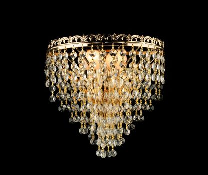 Large golden chandelier isolated over black background